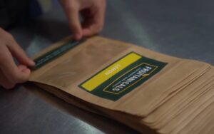 Person assembling garnish craft packs and applying lemon labels.