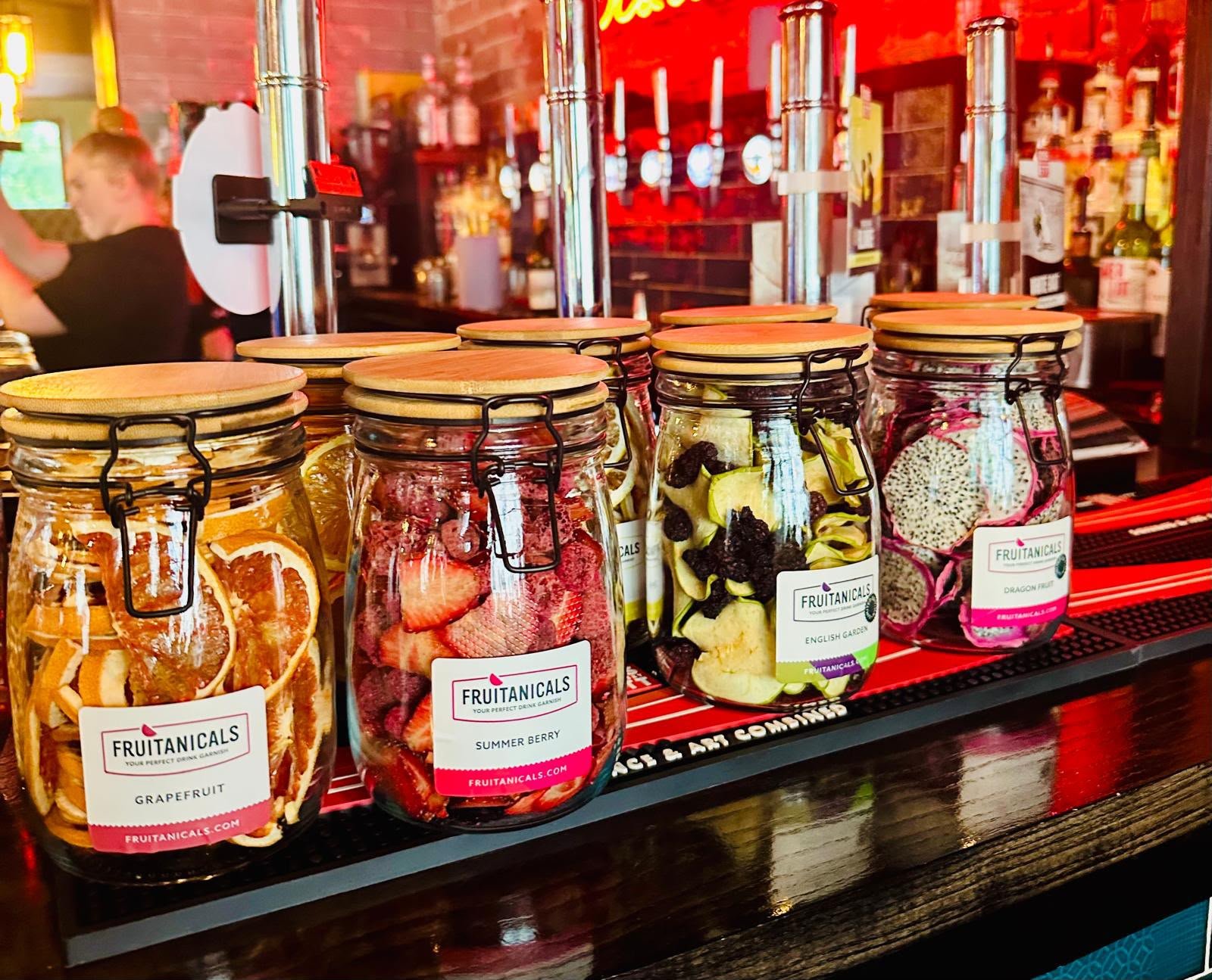 dehydrated fruit in jars laid out on a bar